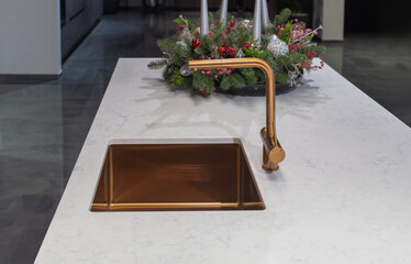 Luxury bronze kitchen sink with matching mixer tap on marble island