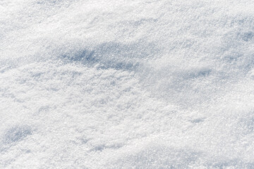 Natural snow surface texture with soft light and subtle shadows. Winter background with copy space, minimal seasonal backdrop.
