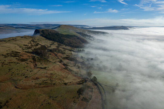 Aerial view of a serene landscape where mist embraces the hills, creating a soft, ethereal boundary between earth and sky, Hope Valley, England, United Kingdom.