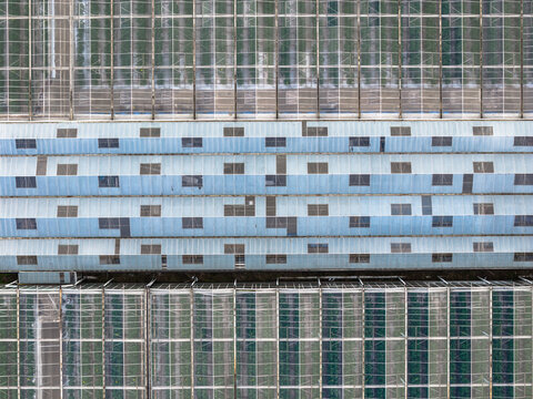 Aerial view of a geometric tapestry of glass and blue panels creating a symmetrical pattern, Tredarzec, Bretagne, France.