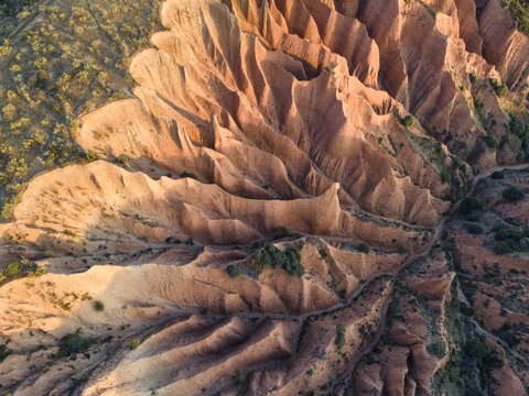 Aerial view of the eroded landscape, carved by time and weather, paints a tapestry of warm hues and rugged textures, Valdepenas de la Sierra, Castile-La Mancha, Spain.