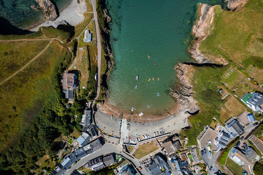 Aerial view of turquoise waters meeting golden sands at Hope Cove, Devon, United Kingdom.