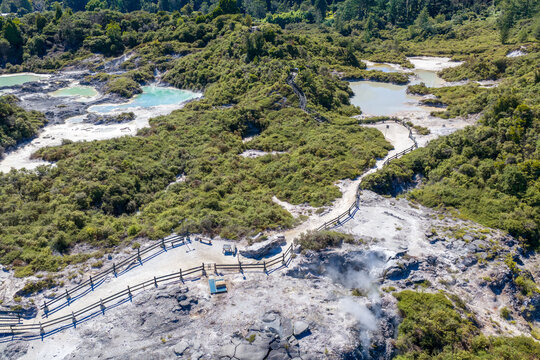 Aerial view of the vibrant geothermal landscape with its steaming vents and colorful pools alongside winding pathways, Rotorua, Bay of Plenty Region, New Zealand.