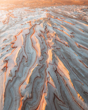 Aerial view of the earth's crust, a symphony of textures and tones painted by nature's brush, where ochre hues meet the stark gray, Kyzylkum, Mangystau Region, Kazakhstan.