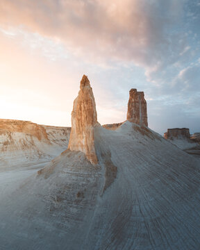 Aerial view of stark white cliffs rising majestically against the dusky sky, a landscape sculpted by time and wind, Aktau, Mangystau Region, Kazakhstan.