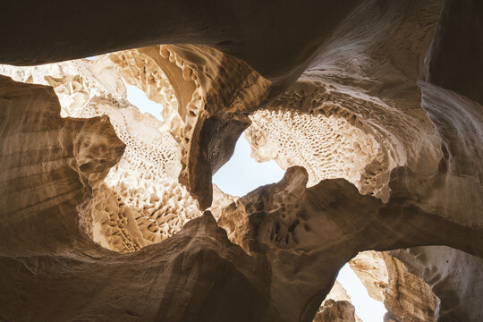 View of weathered rock formations, carved by time and elements, reveal glimpses of the sky above in Koyulus, Mangystau Region, Kazakhstan.