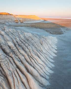 Aerial view of chalky white canyons carved by time under a golden sky, Mangystau, Mangystau Region, Kazakhstan.