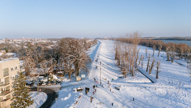 Aerial view of a snow-covered landscape where the Sava River meets the town, creating a striking contrast between the icy river and the white land, Sremska Mitrovica, Vojvodina, Serbia.