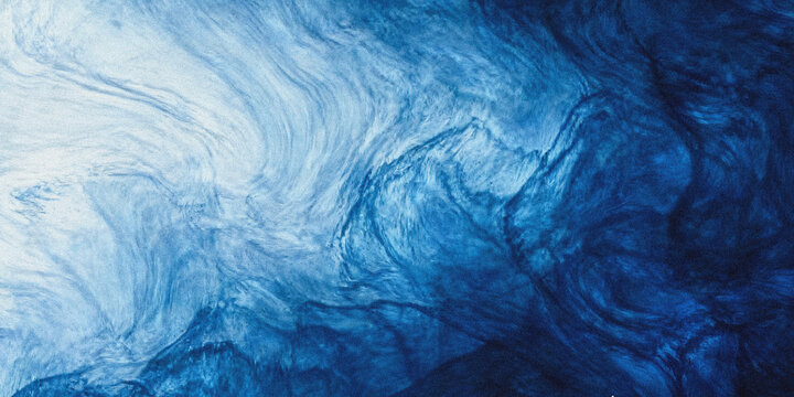 Abstract swirling blue ink in water creates a flowing marbled and ethereal visual texture high quality