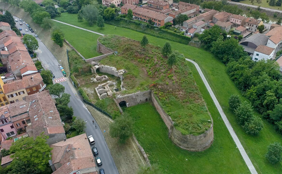 Aerial view of the ramparts of the city walls stand as a testament to time, their weathered brick contrasting with the vibrant green of the grassy embankments, Ferrara, Emilia-Romagna, Italy.
