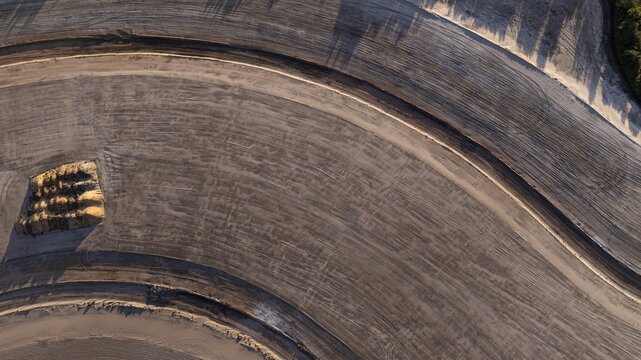 Aerial view of undulating earthworks and soil textures casting shadows and defining the landscape's contours, West Palm Beach, Florida, United States.