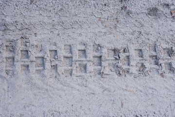 gray texture from a car trail of dry sand and ground on the road
