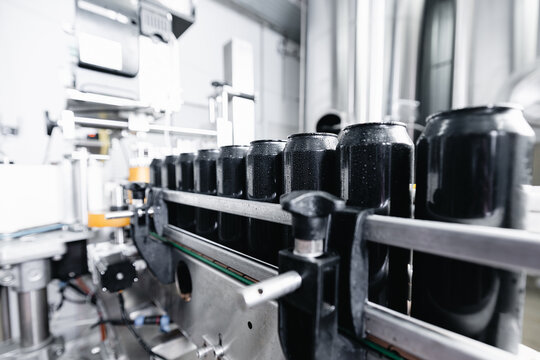 Industrial beer production line with cans in brewery factory