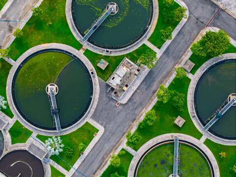 Aerial view of circular settling tanks and modern water cleaning facility at urban wastewater