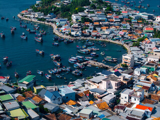 Fishing harbor with boats moored beside densely packed coastal village in Nha Trang Vietnam