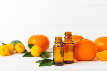 Tangerine essential oil on a wooden table. Bottles of citrus essential oil and sliced ​​fruits. Fragrant tangerine oil with tangerines. Cosmetic oil for spa treatments. Aromatherapy concept. Natural 