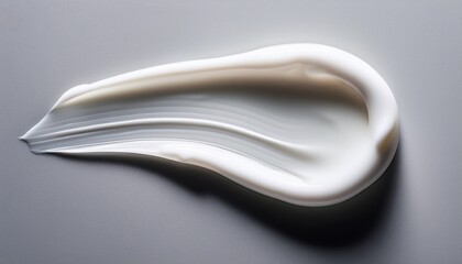 single cosmetic runny lotion swatch on light grey background top view showing texture and color detail soft shadows with clean sharp focus stock photo quality beauty product photography