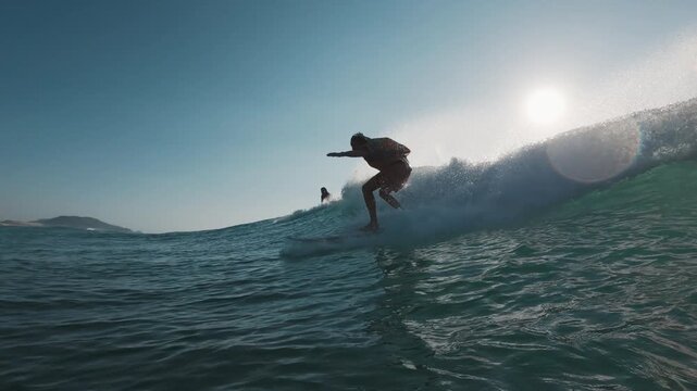 Stylish surfer. Young man in bright colorful shirt surfs the wave. Speed warp effect applied with frozen movement of the rider