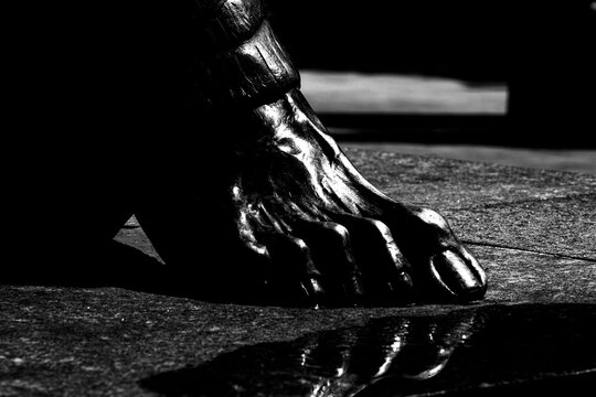 P&eacute; de est&aacute;tua constru&iacute;do com metal. 