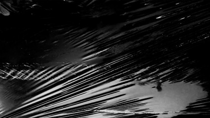 Obraz premium Plastic wrap texture overlay effect on black background. Shrink wrapped plastic sleeve for cover