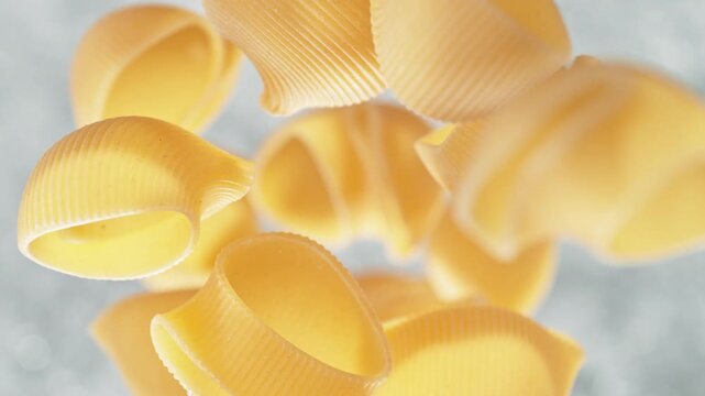 Pipe Rigate Pasta Falling Into Pot Of Boiling Water Making A Splash in Slow Motion, Table Top View