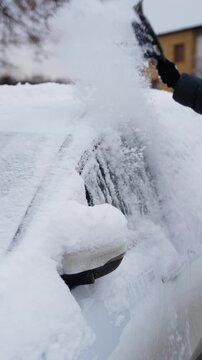 detail - removing ice from a car window in winter - slow motion macro shot