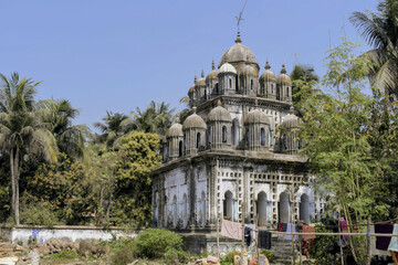ancient 'rashmancha' at narajole, majestic stone structure featuring twenty-five distinct pinnacles arranged in tiers, surrounded by tropical palm trees and lush greenery
