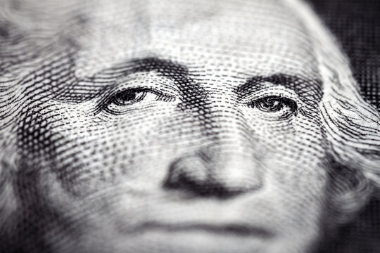 Macro close up of United States one dollar bill. Selective focus on eyes of George Washington. Extreme macro. Shallow depth of field.