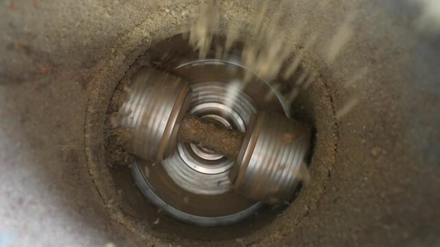 Granulator machine processing material with rotating blades, showing continuous action of grinding and mixing in a cylindrical container