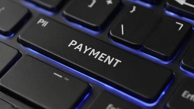 Close-up of illuminated gaming keyboard displaying the word "payment" in vibrant blue neon lights, representing digital transactions and online finances.