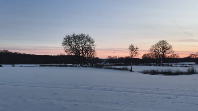 Sonnenuntergang über schneebedeckter Landschaft in Schleswig-Holstein