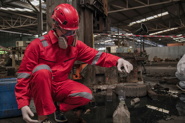 person in mask. Hazardous control related to factory chemicals. Employees are disposing of harmful substances. in a chemical protective suit in a factory