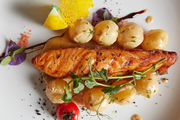 Pan-seared salmon fillet with creamy glazed potatoes and microgreens