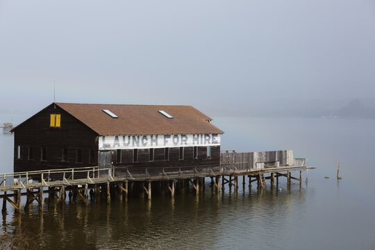 A boat dock with a sign reading &ldquo;Launch For Hire&rdquo; on a cloudy morning in Point Reyes. Point Reyes, California. October 2019
