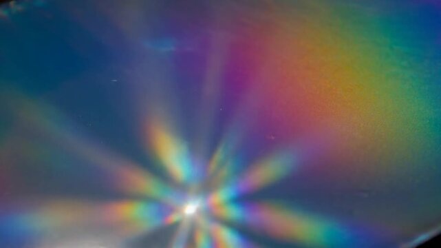 Vibrant rainbow light flare effect with colorful rays and lens burst isolated on dark background