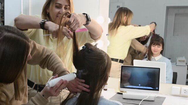 hairdresser examines a young woman's long, natural chestnut hair. A trichologist diagnoses condition of her hair and scalp. Two professional hairdressers trichologists and client looking on screen