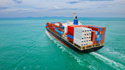 cargo ship, fully loaded with containers, sailed out of the port into the sea.