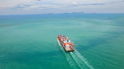 cargo ship, fully loaded with containers, sailed out of the port into the sea.