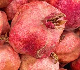  bunch of red pomegranates are piled on top of each other