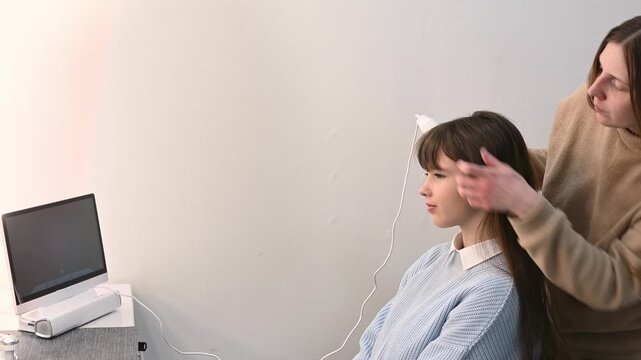 Trichologist examining scalp with digital dermatoscope, close up of hair and skin analysis on screen. Woman specialist performing hair diagnostics procedure in modern clinic, medical consultation conc