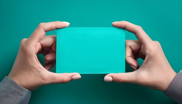 hands presenting turquoise rectangle against vivid teal background