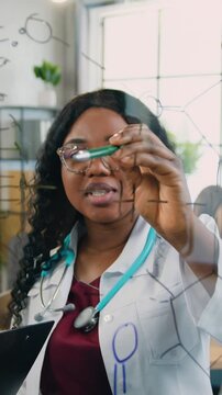 Science concept where professional experienced diverse group of chemists discussing molecular formula of drugs drawn on glass board in medical office to make joint constructive decision,front view