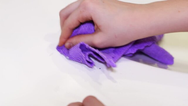 Hand folding a cloth step by step in a workspace
