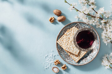 Passover  with matzo, red wine and spring blossoms on blue background. Flat lay, copy space