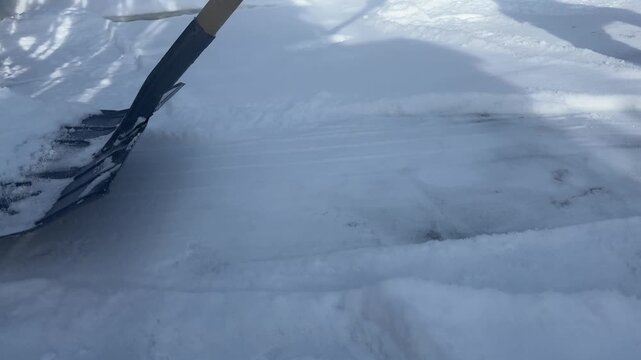 Resident Shoveling Icy Sidewalk Path, Closeup Of Boot And Metal Shovel Scraping Compacted Snow And Ice