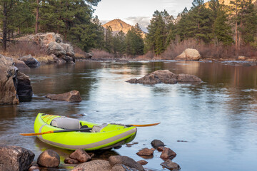 sunset over mountain river with an inflatable whitewater kayak - Poudre River below Mishiwaka, Colorado in early spring