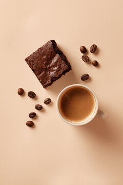 Minimalist flat lay of brownie and coffee on beige background.