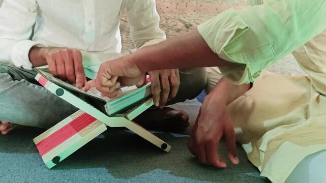 Muslim man teaching Quran reading indoors &ndash; Islamic education and spiritual learning concept