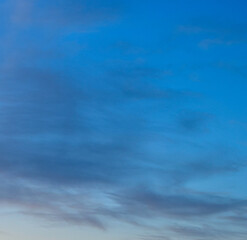 Deep blue twilight sky with soft horizontal evening cloud layers