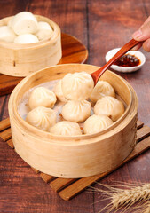 Traditional Chinese Xiao Long Bao Dumplings in Bamboo Steamers with Chopsticks and Sauce for Delicious Dim Sum Breakfast Selection